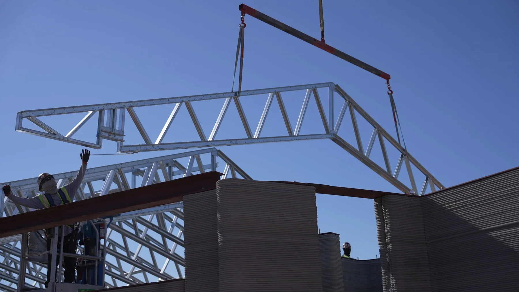 Steel roof truss being lifted into place